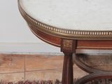 a small table with a marble top on a rug