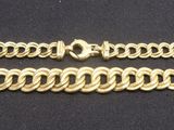 a close up of a gold chain on a black surface