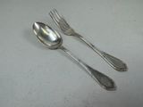 two spoons and a fork sitting on a table