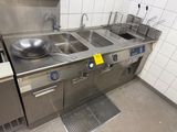 une grande cuisine en inox équipée d'un évier et d'un lave-vaisselle