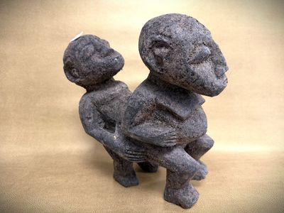 a statue of a man holding a baby on his lap