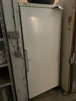 un réfrigérateur blanc dans le coin d'une pièce