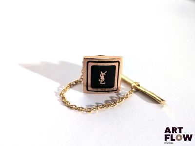 une montre-bracelet noire et dorée, entourée d'une chaîne