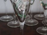 many wine glasses with flowers painted on them on a table