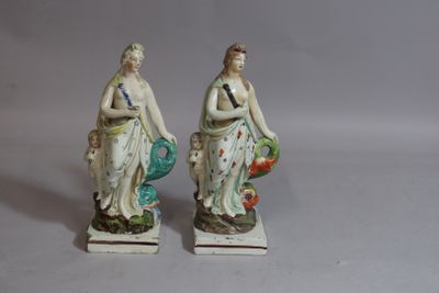 two figurines of a woman with a basket and a man with a bird