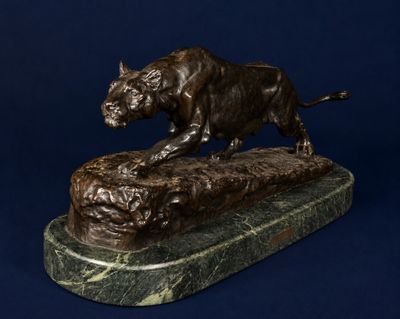 bronze statue of a bull on a rock on a blue background