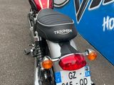 a red motorcycle parked in front of a blue and white bus