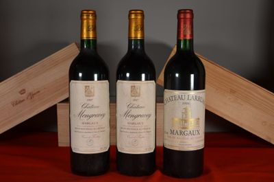 three bottles of red wine sit on a table next to a wooden box