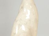 a white cat statue sitting on a white surface