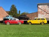 several old cars are parked in front of a brick building