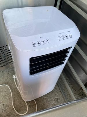 un climatiseur blanc posé à l'intérieur d'un réfrigérateur ouvert