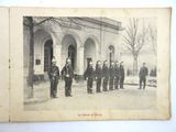 an old photo of a group of men in uniform standing in front of a building