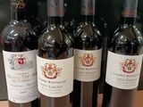 six bouteilles de vin rouge sont alignées sur une table
