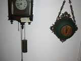 a clock hanging on the wall next to a clock on the wall