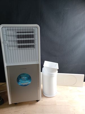 a small air conditioner sitting on a table next to a trash can
