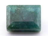 a close up of a green emerald stone on a white surface
