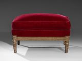 a red velvet foot stool with gilded legs and gold trim
