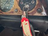 a car dashboard with a clock and a car key hanging from it ' s handle
