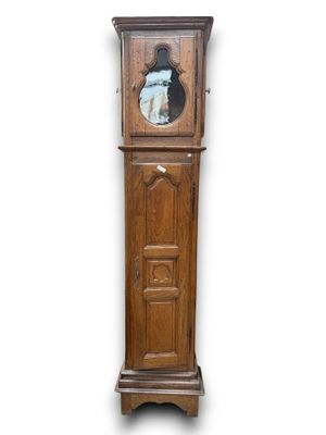 an old wooden grandfather clock with a mirror on the top of it