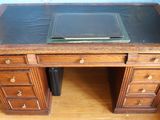 a wooden desk with a glass top in a room