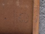 a brown piece of fabric in a wooden frame on the floor