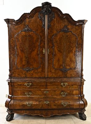 une armoire ancienne en bois ornée de sculptures raffinées sur le dessus