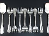 a lot of forks and spoons on a black table