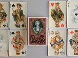 des cartes à jouer sont disposées sur une table où figure une image de la dame de pique