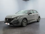 Une voiture grise est garée dans une pièce aux murs blancs.