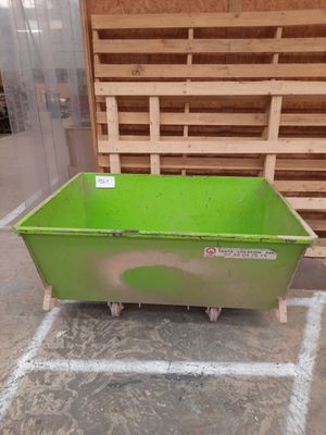 a green container sitting on the floor next to pallets