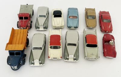 plusieurs petites voitures sont alignées sur une surface blanche