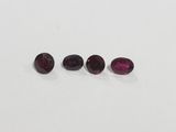 a group of three oval cut garnets on a white surface
