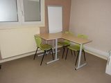 two green chairs and a table in a small room