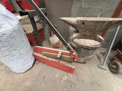 a hammer, an anvil, and a bag of sand on the ground