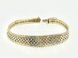gros plan d'un bracelet en or sur une surface blanche