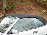 a white car with a black top parked on the side of the road
