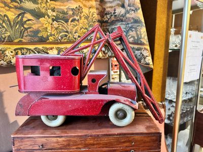 un petit camion rouge posé sur une caisse en bois