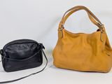 two pieces of leather handbags sitting next to each other on a white surface