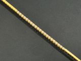 an image of a gold and diamond bracelet on a black surface