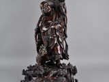 Statue chinoise en bois sculpté représentant une personne assise sur une souche d'arbre