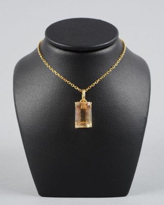 un collier plaqué or avec un pendentif en verre de forme carrée, monté sur une chaîne en or