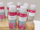 six flacons de gel hydroalcoolique posés sur un support en bois