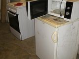 a small kitchen with a stove, microwave, and refrigerator