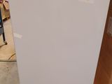 a white refrigerator sitting on a pallet in a warehouse