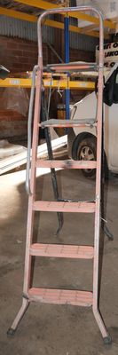 a ladder that is sitting in a garage next to a van