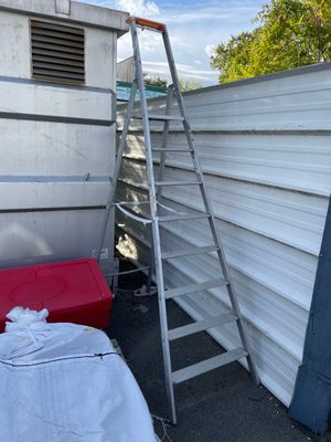 une échelle appuyée contre un mur, à côté d'un lit