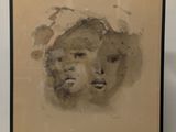painting of a woman ' s face in a black frame on a white wall