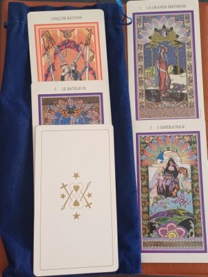 quatre cartes de tarot posées sur une table, à côté d'un sac bleu
