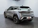 the rear end of a silver car parked in a showroom