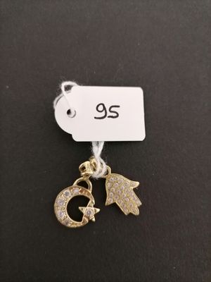 a close up of a gold charm with a cat on it